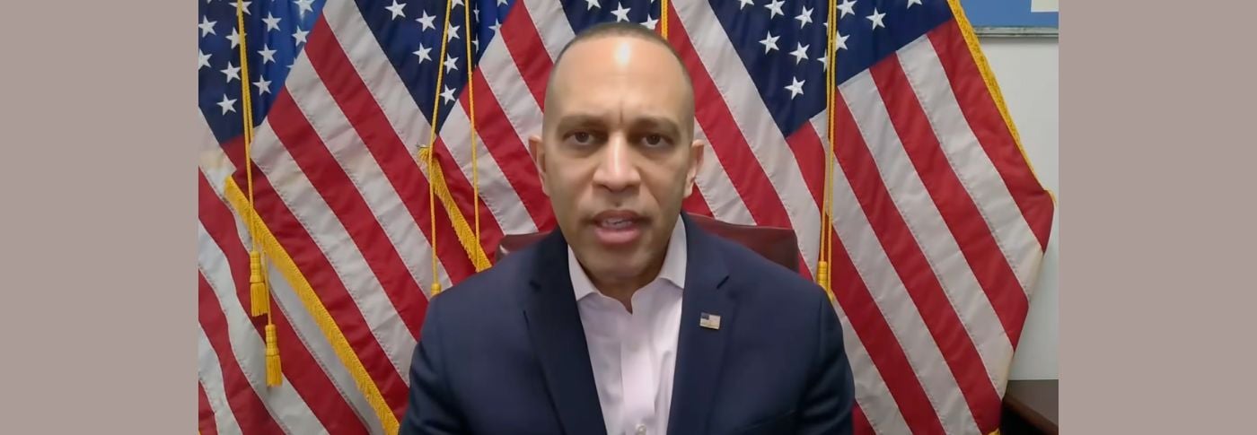 Speaker Hakeem Jeffries speaks during a PBS interview about Democrats withholding funding for the Department of Homeland Security, with American flags behind him.